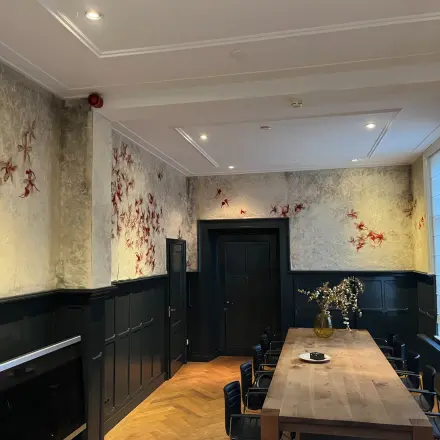 Charming office space with elegant wood paneling and decorative wall accents at Oude Enghweg 8, Hilversum. Ideal for office space rental with natural light and a large meeting table perfect for collaboration.