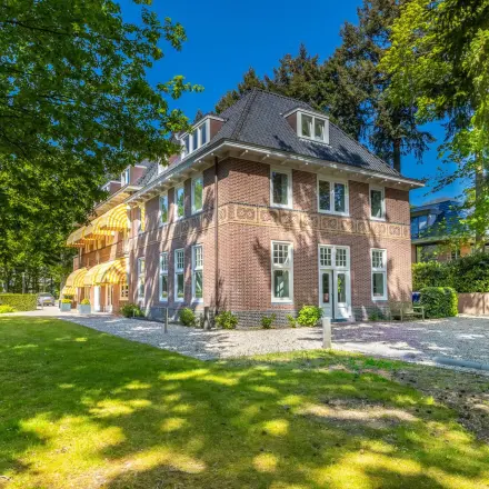 Exterior view of a red-brick office building surrounded by trees at Utrechtseweg 47, ideal for office space rental.
