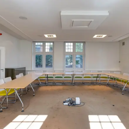 Bright office space rental at Utrechtseweg 47 in Hilversum featuring a spacious room with a U-shaped table arrangement, ideal for meetings.