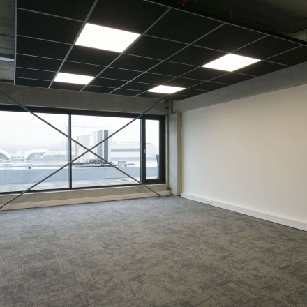 Spacious office for rent at Zuiderloswal 55, Hilversum, featuring large windows and modern carpeting, perfect for an adaptable office space rental.