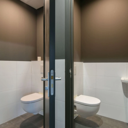 Compact restroom at office space rental on Zuiderloswal 55, Hilversum, featuring minimalist design and modern fixtures.