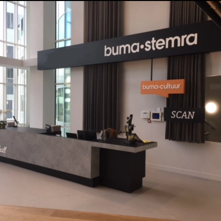 Reception area at Saturnusstraat 40-62 in Hoofddorp, featuring a modern counter and signage. Ideal for those looking to rent office space in a contemporary setting.