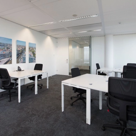 Bright, modern office featuring multiple workstations and minimalistic design at Saturnusstraat 40-62, Hoofddorp. Ideal for office space rental, offering ample natural light and sleek furnishings.