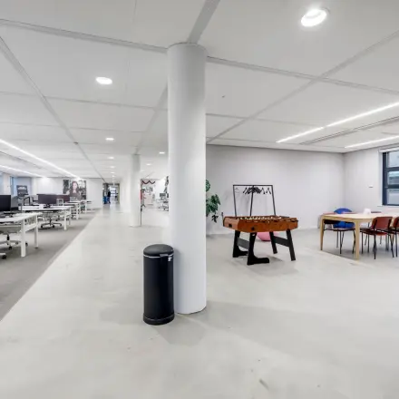 Spacious and modern office to rent in Hoofddorp at Siriusdreef 16, featuring an open floor plan with desks, chairs, and a foosball table, ideal for collaborative workspaces.