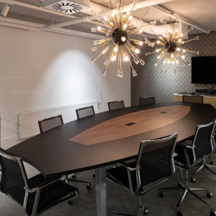 Modern conference room at Siriusdreef 60, Hoofddorp, featuring a stylish oval table, sleek chairs, and unique lighting fixtures. Ideal for office space rental, this setup encourages professional collaboration.