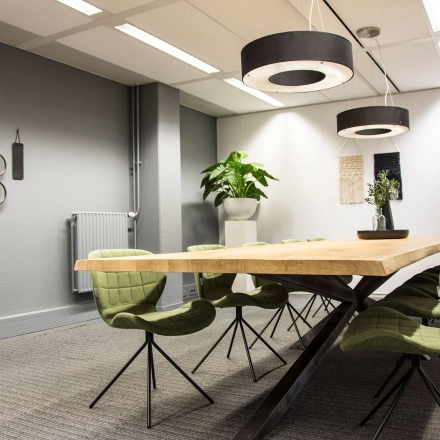 Spacious, well-lit office meeting room with wooden table and modern chairs at Meidoornkade 22, perfect for office space rental.