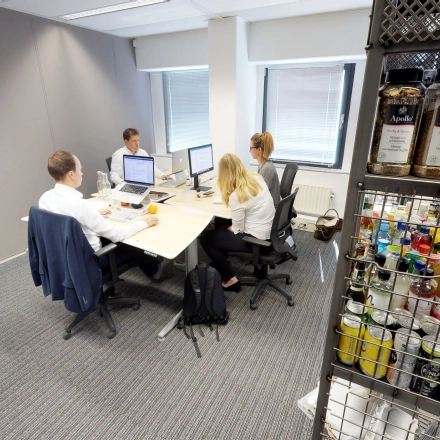 Professionals collaborate at desks in a furnished office space at Meidoornkade 22, Houten, highlighting a practical office to rent with ample workspace facilities.