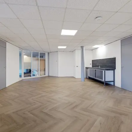 Empty office space with wooden floor and kitchenette at Ouddeelstraat 7a, Leeuwarden, ideal for office space rental.
