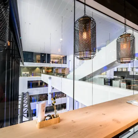 Modern office interior at Bargelaan 200, Leiden, showcasing a sleek workspace for office space rental with ambient lighting and contemporary design.