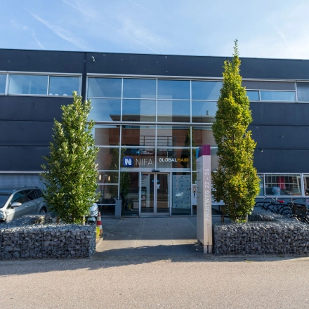 Exterior view of office space rental at Fruitweg 22, Leiden, featuring a modern facade with ample parking and bicycle racks.