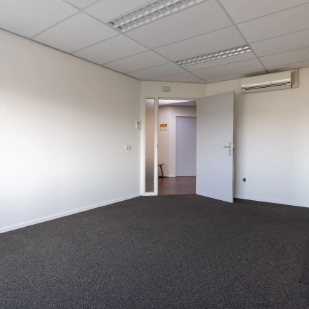 Empty office space at Fruitweg 22, Leiden, ideal for rent. Neutral walls and carpet offer a versatile area for office space rental.