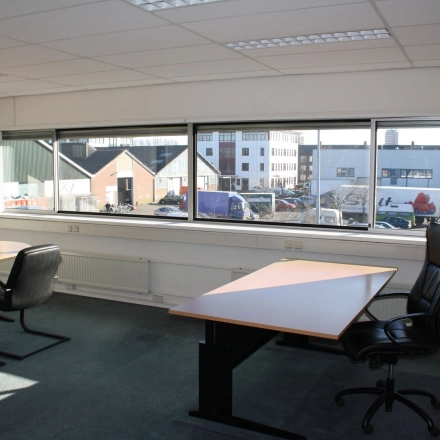 Spacious office to rent at Fruitweg 22, Leiden, featuring large windows and modern furnishings. Ideal for professionals seeking office space rental with ample natural light.
