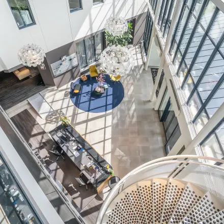 A modern office space at Kanaalpark 140 in Leiden featuring a spacious reception area with contemporary seating, plants, and decorative lighting. Ideal for office space rental.