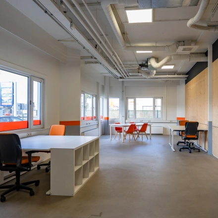 Interior view of an office space at Touwbaan 38, Leiderdorp, featuring modern workspaces with desks and chairs bathed in natural light through large windows; ideal for office space rental.