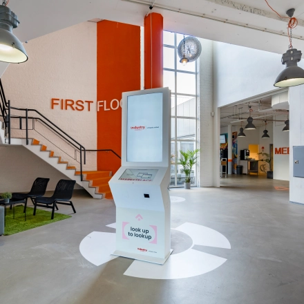 Modern, inviting office entrance at Touwbaan 38 in Leiderdorp, featuring sleek seating and a digital kiosk, ideal for businesses seeking office space rental with a contemporary feel.