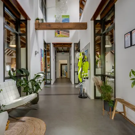 View of a bright, furnished office interior at Hamersveldseweg 120, Leusden, available for rent. The space features seating, plants, and décor, ideal for office space rental seekers.