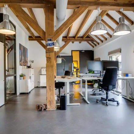 Spacious office space at Hamersveldseweg 120, Leusden, featuring modern desks and exposed wooden beams, available for rent. Ideal for office space rental.