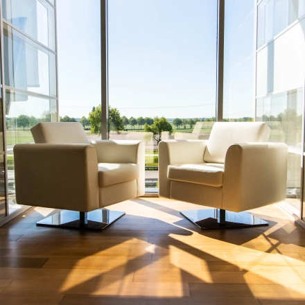 Bright office space with two modern chairs and large window view at Brieltjenspolder 28, Made, ideal for office space rental.