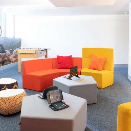 Colorful, modern office space at Calle de la Caléndula 93 in Madrid Alcobendas, featuring vibrant seating and a foosball table, ideal for rent office space or office space rental.