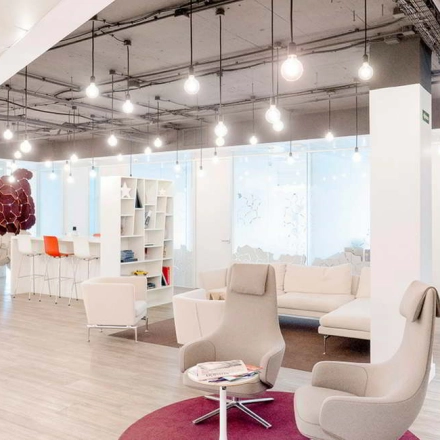 Modern office space at Paseo de la Castellana 79, Madrid Azca, with contemporary furnishings including lounge chairs and a sofa, ideal for office space rental.