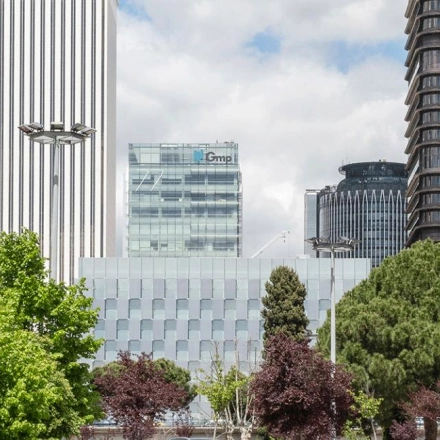 View of the skyline near Paseo de la Castellana 79 in Madrid Azca, featuring modern office buildings and greenery.