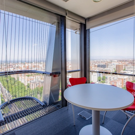 Bright office space at Paseo de la Castellana 95, Madrid Azca, featuring large windows with city views and modern furnishings, ideal for office space rental.