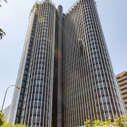 Tall modern building with unique architecture located at Paseo de la Castellana 95, Madrid Azca, ideal for office space rental.