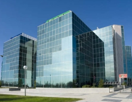 Modern glass office building located at Avenida del Partenón 16-18 in Madrid Barajas, ideal for rent office space with large windows and sleek design.