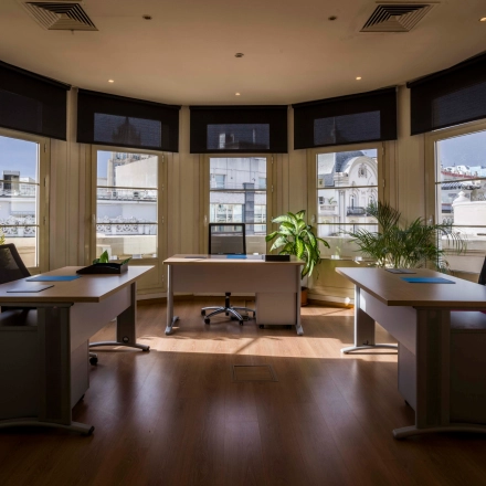 Spacious office to rent at Calle Gran Vía 6, Madrid Center, featuring three desks with chairs, large windows, and natural light for ideal office space rental.