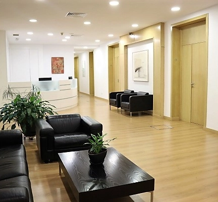 Spacious office interior with modern furniture, located on Calle Gran Vía 6, Madrid Center, perfect for office space rental. Comfortable seating and contemporary art create an inviting atmosphere for business activities.