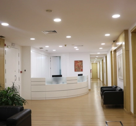Spacious office reception area at Calle Gran Vía 6 in Madrid Center. Features a sleek front desk, seating area, and bright lighting, ideal for office space rental.