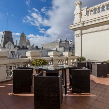 Outdoor terrace with wicker furniture on Calle Gran Vía 6, perfect for breaks during office space rental in Madrid Center.