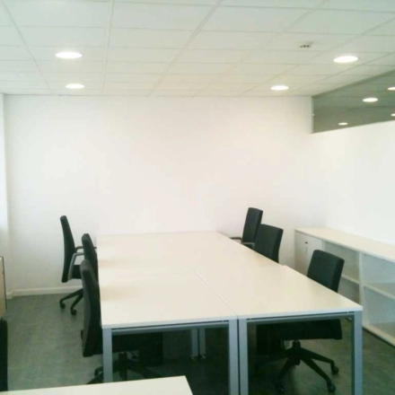 Furnished office space for rent at Plaza Santa María Soledad Torres Acosta 1 in Madrid Center, featuring bright lighting and modern chairs.