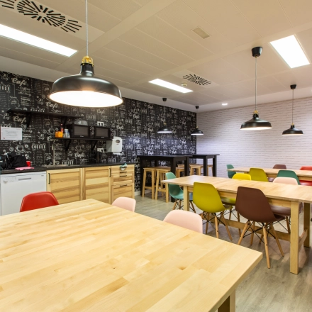 Bright, furnished office space for rent on calle de O'Donnell in Madrid Retiro, featuring modern tables and chairs in a welcoming environment.