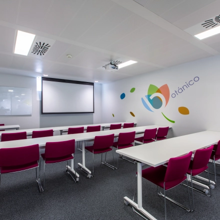 Office space rental in Madrid's Retiro district, featuring a conference room with modern furnishings and bright seating, perfect for professional meetings.