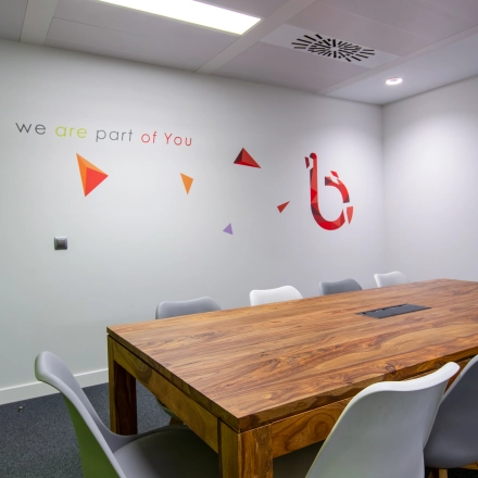 Interior office space in Madrid Retiro on calle de O'Donnell, featuring a modern conference room with a large wooden table and chairs, ideal for office to rent opportunities.