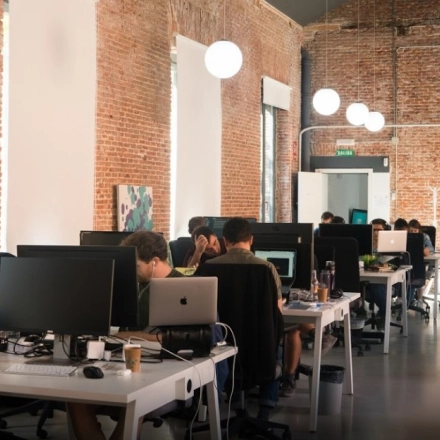 Modern office space for rent on Calle Vandergoten 1, Madrid Retiro, featuring open workstations and professionals engaged in computer work.