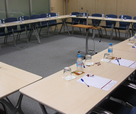 Office space rental at Avenida de Brasil 6, Madrid Tetuán with a conference room setup featuring tables, chairs, and water bottles arranged for a meeting.