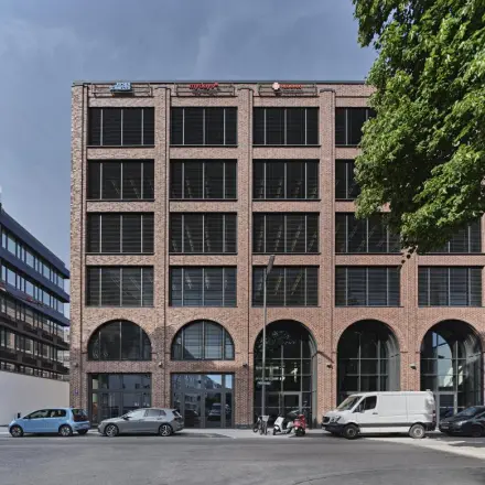 Exterior view of the brick office building at Mühldorfstraße 8, München Werksviertel, showing a potential office space rental opportunity.