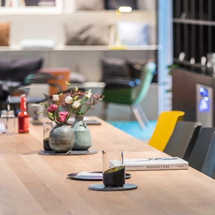 Modern office space available for rent at Rosenheimer Straße 143C, München Werksviertel, featuring a long wooden table with colorful chairs and a cozy, inviting atmosphere.