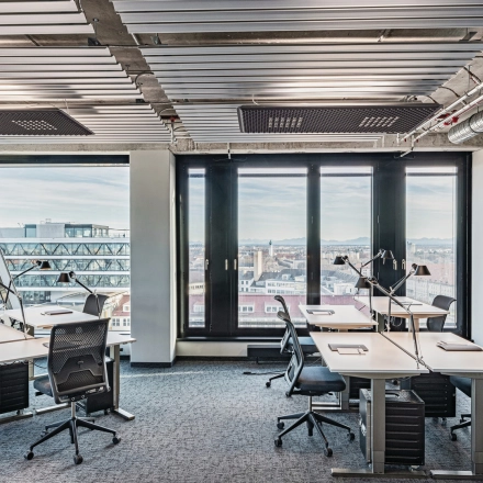Modern office space with panoramic views at Rosenheimer Straße 143C, München Werksviertel, available for rent. The bright office features multiple desks and chairs, perfect for collaborative work.