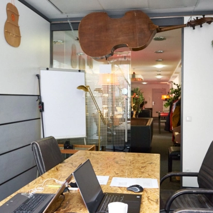 Furnished office space at Werinherstraße 3, Munich Giesing, featuring a table with laptops and a flipchart, ideal for office space rental.