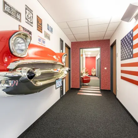 Hallway featuring retro car hood and American flag details, offering a creative office space rental style.