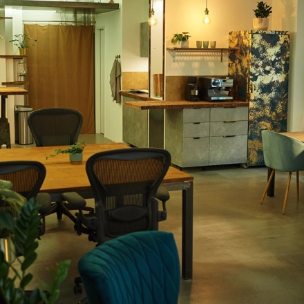 Stylish office at Amalienstraße 71, Munich Maxvorstadt with modern furniture, greenery, and a coffee station, ideal for office space rental.
