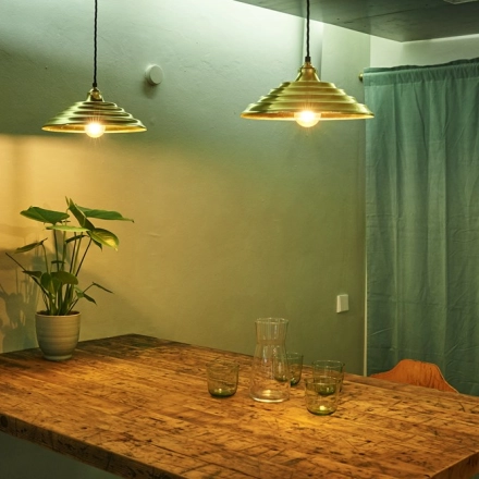 Cozy office space for rent in Munich Maxvorstadt at Amalienstraße 71, featuring wooden table, pendant lighting, and plant decor.