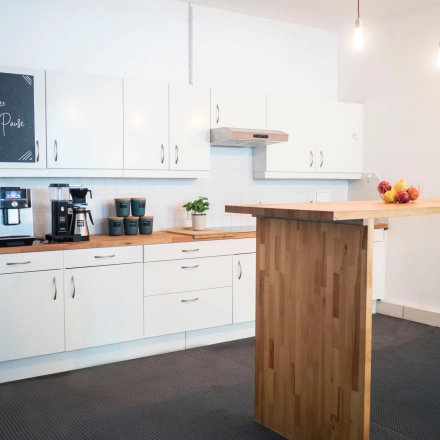 Modern furnished office kitchen area at Blütenstraße 15 in Munich Maxvorstadt, featuring a sleek design and equipped for efficient workspace needs.