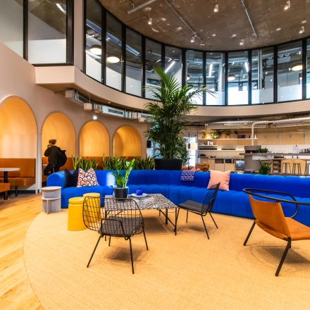 Modern office space rental at Oskar-von-Miller-Ring 20 with vibrant seating, stylish furniture, and a coworking area. Suitable for professionals looking to rent office space in Munich Maxvorstadt.