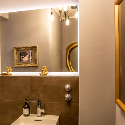 Stylish restroom interior at Marienplatz 17, featuring elegant decor with framed artwork and modern lighting. Ideal for those seeking office space rental with sophisticated amenities.