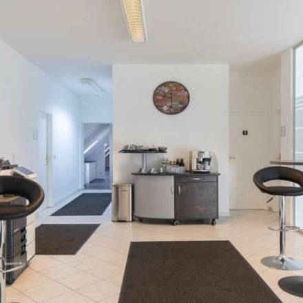 Bright office space at Fürstenrieder Straße 275 in Munich Sendling, featuring tall tables and chairs, ideal for short meetings. Ideal office space rental with modern furnishings and ample natural light.