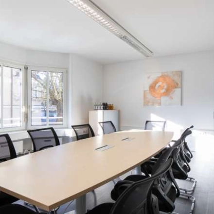 Bright office space rental at Fürstenrieder Straße 275 in Munich Sendling, featuring a conference room with a large table and ergonomic chairs, ideal for team meetings.